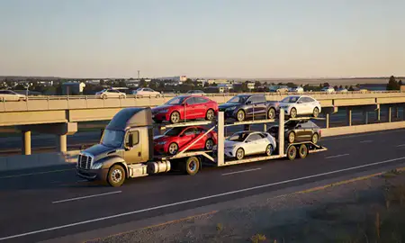 Car transporter with the Belgrade, Montana, United States skyline behind it