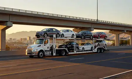 Car transporter with the Bozeman, Montana, United States skyline behind it