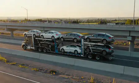 Car transporter with the Orchard Homes, Montana, United States skyline behind it