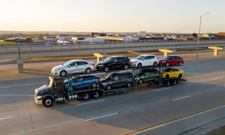 Car transporter with the Ralston, Nebraska, United States skyline behind it