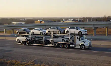 Car transporter with the Schuyler, Nebraska, United States skyline behind it