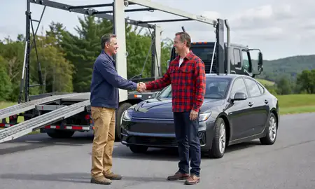 Vehicle owner beside their delivered car in New Hampshire, United States