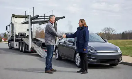 Vehicle owner beside their delivered car in Berlin, New Hampshire, United States