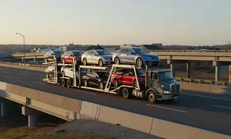 Car transporter with the Groveton, New Hampshire, United States skyline behind it
