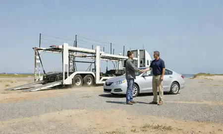 Vehicle owner beside their delivered car in Seabrook Beach, New Hampshire, United States