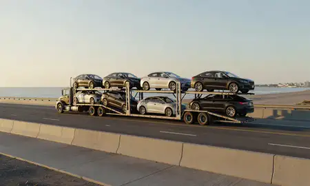 Car transporter with the Seabrook Beach, New Hampshire, United States skyline behind it