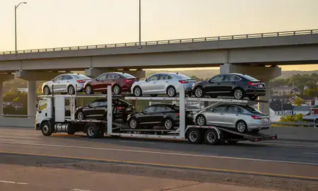 Car transporter with the West Swanzey, New Hampshire, United States skyline behind it