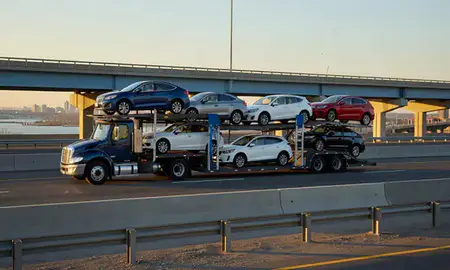 Car transporter with the New Jersey, United States skyline behind it