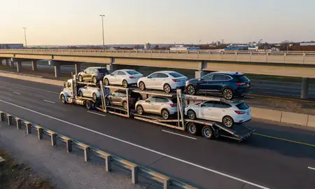 Car transporter with the Sicklerville, New Jersey, United States skyline behind it