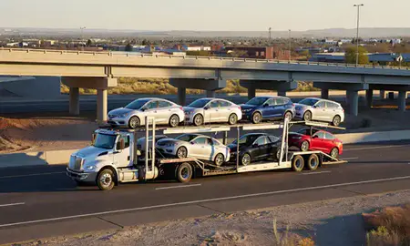 Car transporter with the Deming, New Mexico, United States skyline behind it