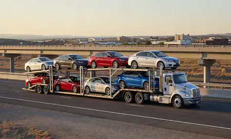 Car transporter with the Gallup, New Mexico, United States skyline behind it