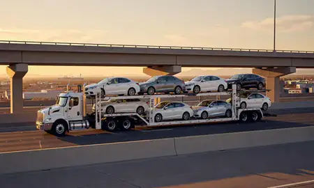 Car transporter with the Las Vegas, New Mexico, United States skyline behind it