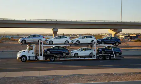 Car transporter with the Roswell, New Mexico, United States skyline behind it