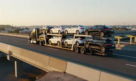 Car transporter with the Coram, New York, United States skyline behind it
