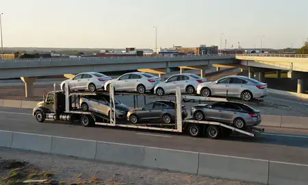 Car transporter with the Concord, North Carolina, United States skyline behind it