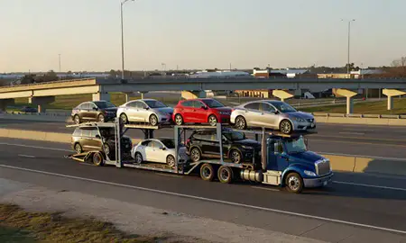 Car transporter with the Goldsboro, North Carolina, United States skyline behind it