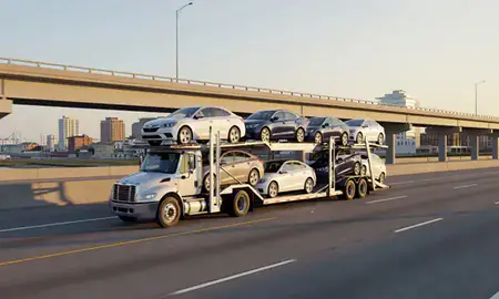 Car transporter with the Wilmington, North Carolina, United States skyline behind it