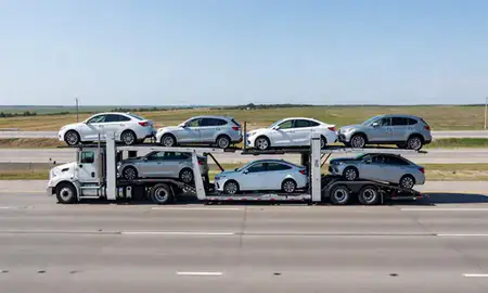 Multi-level car carrier on the highway to Belcourt, North Dakota, United States