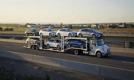 Car transporter with the Hazen, North Dakota, United States skyline behind it