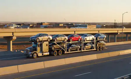 Car transporter with the Minot, North Dakota, United States skyline behind it