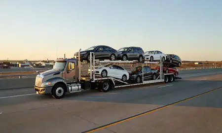 Car transporter with the New Town, North Dakota, United States skyline behind it