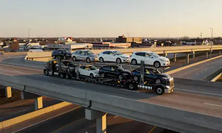 Car transporter with the Fairfield, Ohio, United States skyline behind it