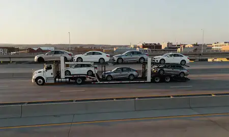 Car transporter with the Grove City, Ohio, United States skyline behind it