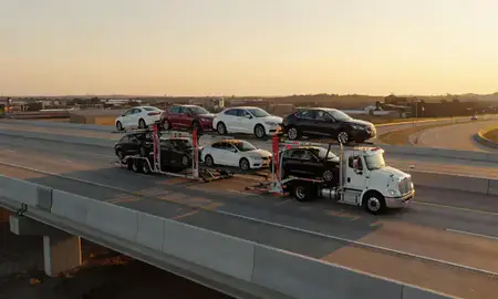 Car transporter with the Claremore, Oklahoma, United States skyline behind it
