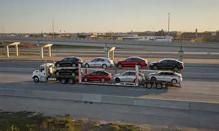 Car transporter with the Durant, Oklahoma, United States skyline behind it