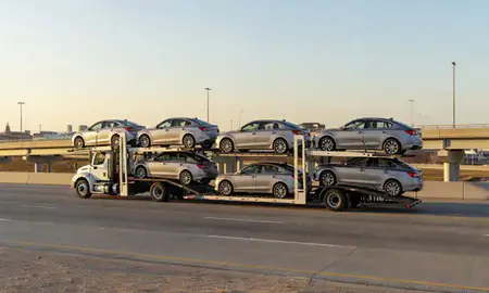 Car transporter with the Moore, Oklahoma, United States skyline behind it