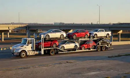 Car transporter with the Stillwater, Oklahoma, United States skyline behind it