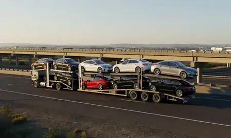 Car transporter with the Corvallis, Oregon, United States skyline behind it