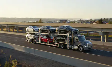 Car transporter with the Grants Pass, Oregon, United States skyline behind it