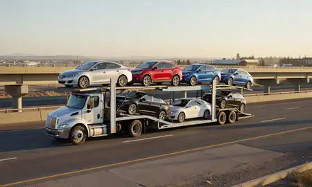 Car transporter with the Keizer, Oregon, United States skyline behind it