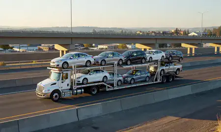 Car transporter with the McMinnville, Oregon, United States skyline behind it