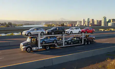 Car transporter with the Portland, Oregon, United States skyline behind it