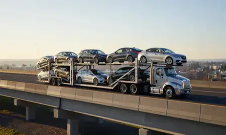 Car transporter with the Springfield, Oregon, United States skyline behind it