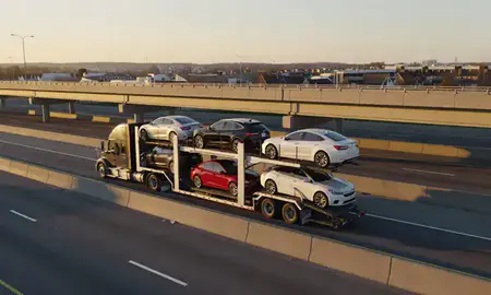 Car transporter with the Levittown, Pennsylvania, United States skyline behind it