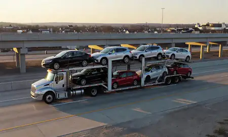 Car transporter with the Plum, Pennsylvania, United States skyline behind it