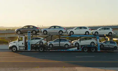 Car transporter with the Vega Baja, Puerto Rico, United States skyline behind it