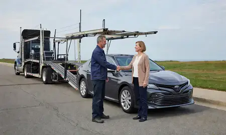 Vehicle owner beside their delivered car in Rhode Island, United States