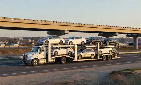 Car transporter with the Bradford, Rhode Island, United States skyline behind it