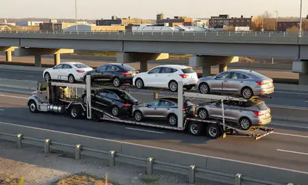 Car transporter with the Pawtucket, Rhode Island, United States skyline behind it