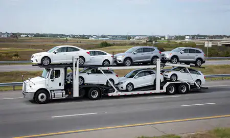 Multi-level car carrier on the highway to Quonochontaug, Rhode Island, United States