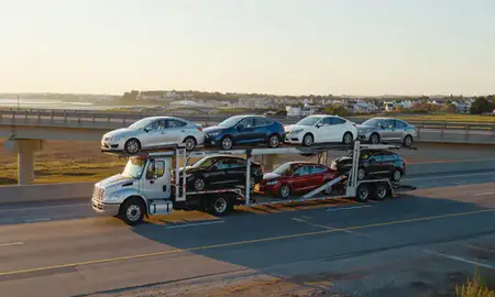 Car transporter with the Quonochontaug, Rhode Island, United States skyline behind it