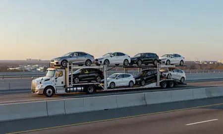 Car transporter with the Carolina Forest, South Carolina, United States skyline behind it