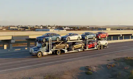 Car transporter with the Brookings, South Dakota, United States skyline behind it