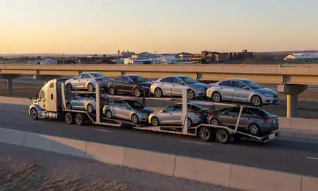 Car transporter with the Dakota Dunes, South Dakota, United States skyline behind it