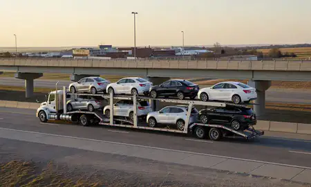 Car transporter with the Harrisburg, South Dakota, United States skyline behind it