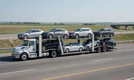 Multi-level car carrier on the highway to Madison, South Dakota, United States